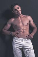 hübsches arabisches männliches Model mit perfektem Körper posiert im Studio. Porträt eines athletischen männlichen Modells, das auf dunklem Hintergrund im Studio posiert. Modekonzept. foto