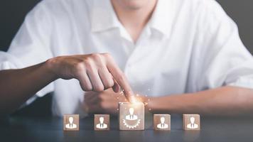 hrm oder personalmanagement, strategische planung für erfolg durch menschen geschäftsentwicklungskonzept durch auswahl professioneller führer mitarbeiterkompetenz teamwork, mann zeigt auf holzblock foto