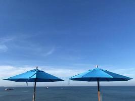 blauer Sonnenschirm auf Sommerhintergrund des blauen Himmels foto