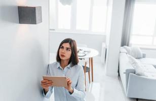 Beleuchtung schalten. junge frau ist tagsüber drinnen im smart house room foto