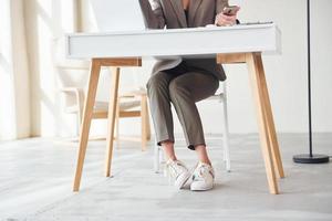 junge Frau in formeller Kleidung ist drinnen. Vorstellung von Stil foto