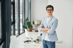 junge kerle mit brille und formeller kleidung stehen im büro foto