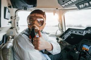 in Sauerstoffmaske. Pilot bei der Arbeit im Passagierflugzeug. Vorbereitung für den Start foto