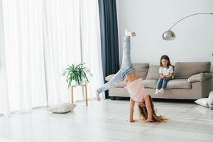 Kinder, die sich tagsüber gemeinsam im Wohnzimmer amüsieren foto