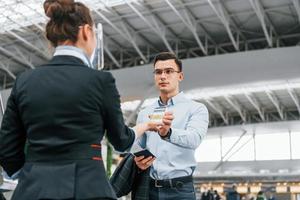 Mann zeigt Impfpass. Der junge Geschäftsmann in formeller Kleidung ist tagsüber am Flughafen foto