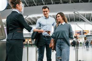 Dokumentenkontrolle am Eingang. junges paar ist zusammen am flughafen foto