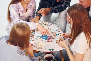 Puzzlespiel spielen. gruppe von freunden feiern zusammen drinnen foto