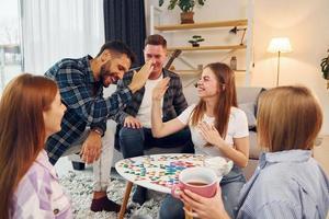 intelligentes Spiel spielen. gruppe von freunden feiern zusammen drinnen foto