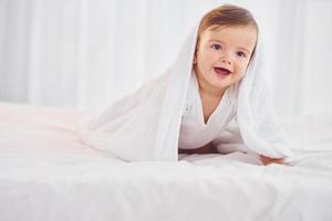 mit weißem Tuch. süßes kleines baby ist drinnen im wohnzimmer foto