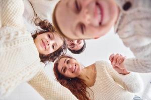 lächeln und Spaß haben. Ansicht von unten. Glückliche Familie, die nach unten schaut foto