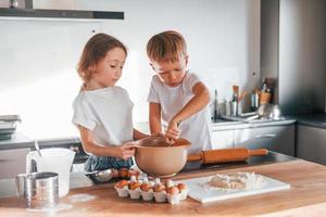 gemeinsam Essen zubereiten. kleiner Junge und Mädchen in der Küche foto