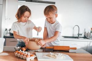 gemeinsam Essen zubereiten. kleiner Junge und Mädchen in der Küche foto