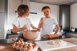 Weihnachtsplätzchen zubereiten. kleiner Junge und Mädchen in der Küche foto