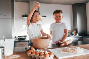 Wochenendaktivitäten. kleiner Junge und Mädchen, die Weihnachtsplätzchen in der Küche zubereiten foto