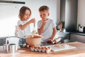 Wochenendaktivitäten. kleiner Junge und Mädchen, die Weihnachtsplätzchen in der Küche zubereiten foto