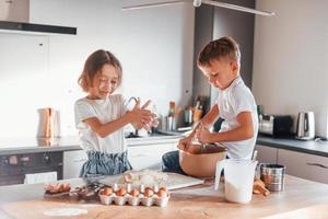 Süßigkeiten machen. kleiner Junge und Mädchen, die Weihnachtsplätzchen in der Küche zubereiten foto