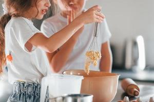 Kochen lernen. kleiner Junge und Mädchen, die Weihnachtsplätzchen in der Küche zubereiten foto