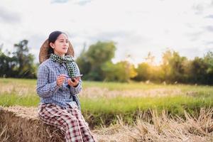 Bäuerin mit Technologiemobil im Reisfeld foto