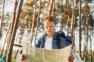 Karte verwendet. Der Mensch ist im Sommer tagsüber allein im Wald unterwegs foto