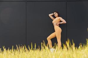 grünes Gras. junge Frau in Sportbekleidung hat eine Fitness-Session im Freien foto
