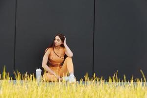 sitzt auf dem Boden. junge Frau in Sportbekleidung hat eine Fitness-Session im Freien foto