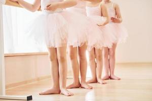 Nahaufnahme. kleine Ballerinas bereiten sich auf den Auftritt vor, indem sie Tanzbewegungen üben foto