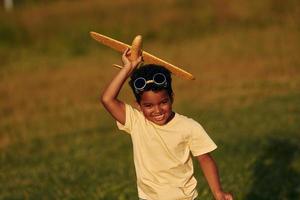 Wochenendaktivitäten. afroamerikanisches kind hat tagsüber im sommer spaß auf dem feld foto