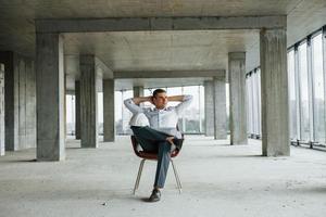 Geschäftsmann im Gebäude. junger mann in formeller kleidung arbeitet drinnen am bau foto