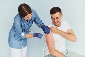 mit Spritze. Arzt in Uniform, der dem Patienten eine Impfung vornimmt foto