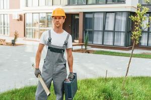 fertig für die Arbeit. junger Mann in Uniform tagsüber auf dem Bau foto