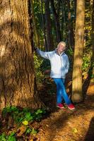 attraktive blonde Frau, die auf einer Naturwanderung im Wald spazieren geht. foto