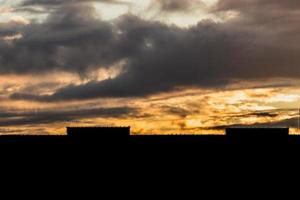 Bewölkter Sonnenaufgang über einer Brückensilhouette am Morgen foto