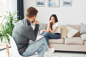 junge Frau bei einem Empfang bei einem Psychologen. sitzt auf dem Sofa foto