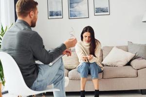 junge Frau bei einem Empfang bei einem Psychologen. sitzt auf dem Sofa foto