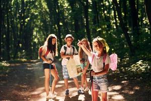 mit touristischer Ausstattung. Kinder, die im Wald spazieren gehen foto