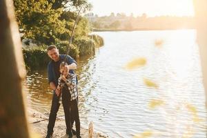 etwas zu essen. Vater und Sohn beim gemeinsamen Angeln im Freien im Sommer foto