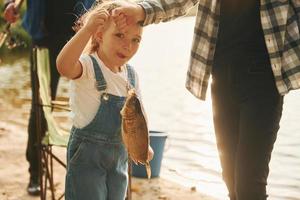 Vater mit Sohn und Tochter beim gemeinsamen Angeln im Freien im Sommer foto