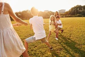 Tauziehen spielen. Eine Gruppe glücklicher Kinder ist tagsüber draußen auf dem Sportplatz foto