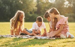 eine gruppe glücklicher kinder ist tagsüber draußen auf dem sportplatz foto