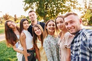 ein Selfie machen. Eine Gruppe junger Leute feiert tagsüber im Sommer eine Party im Park foto