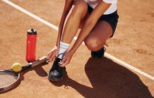 Schuhe tragen. Tennisspielerin ist tagsüber auf dem Platz foto