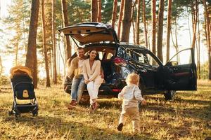 Spaß und Freude. Familie von Vater, Mutter und kleiner Tochter ist im Wald foto