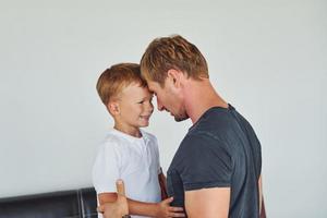 einander umarmen. Vater und Sohn sind zusammen zu Hause foto