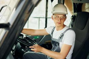 Fahrer ist bei der Arbeit. Mann in Berufsuniform ist tagsüber in der Leihgrube foto