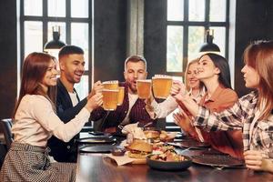 junge Erwachsene. gruppe junger freunde, die zusammen in der bar mit bier sitzen foto