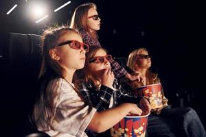 Seitenansicht. gruppe von kindern, die im kino sitzen und zusammen filme ansehen foto