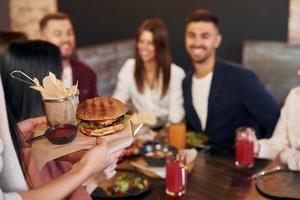 miteinander ins Gespräch kommen. gruppe junger freunde, die zusammen in der bar mit bier sitzen foto