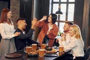 Wohlbefinden der Menschen. gruppe junger freunde, die zusammen in der bar mit bier sitzen foto