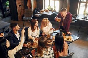 nette Stimmung. gruppe junger freunde, die zusammen in der bar mit bier sitzen foto