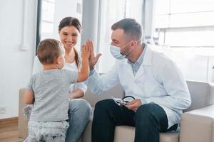 mit kleinem Jungen. Zwei Ärzte in weißen Kitteln arbeiten in der Klinik zusammen foto